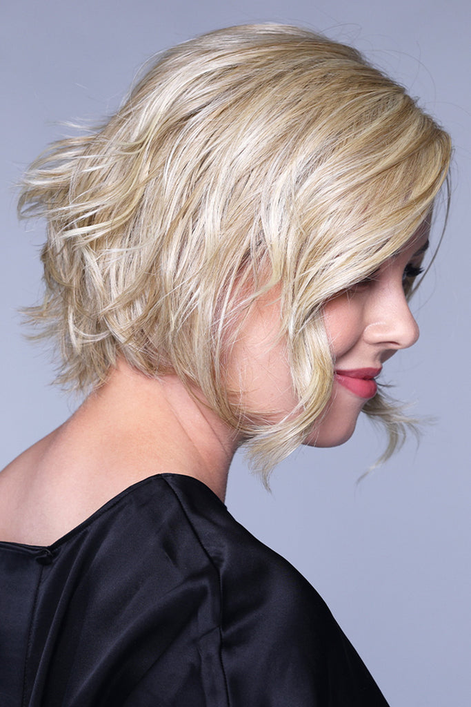 Side view of a woman wearing the wavy blonde style. 