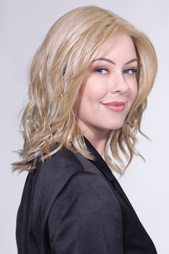 Side view of women styling a pale blonde base wig with honey blonde highlights.