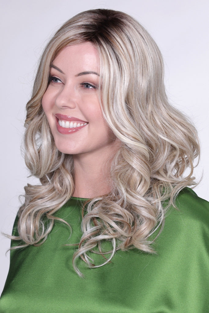 Side view of woman wearing a cool blonde wig with a touch of honey blonde woven throughout and a dark root.