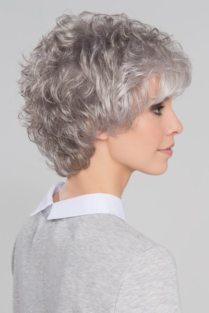 Side view of model wearing a curly shaggy wig.