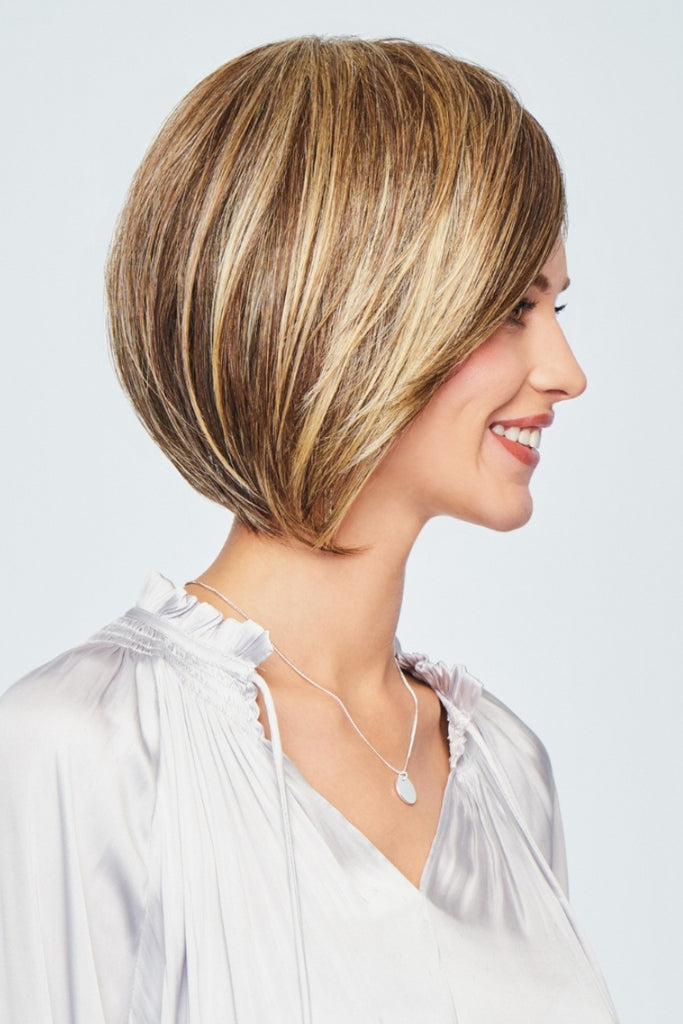Side view of model wearing a longer bob cut wig with face framing layers.