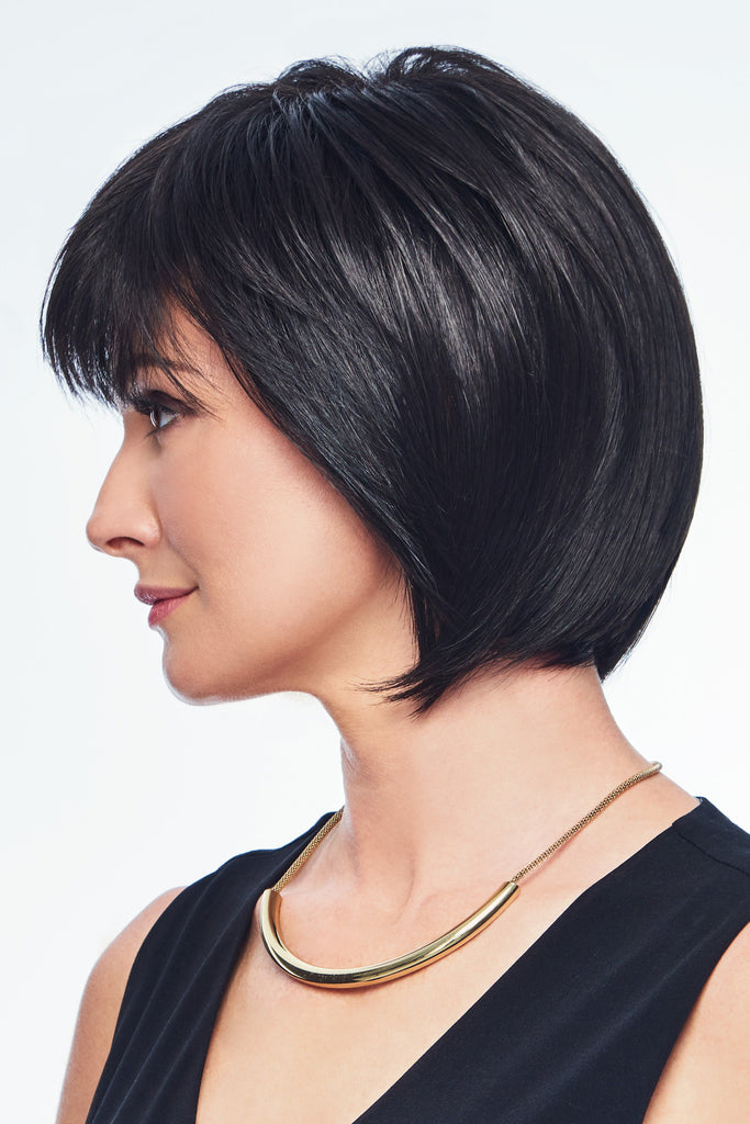Side photo of a woman wearing a bob wig that comes just below the jawline. 