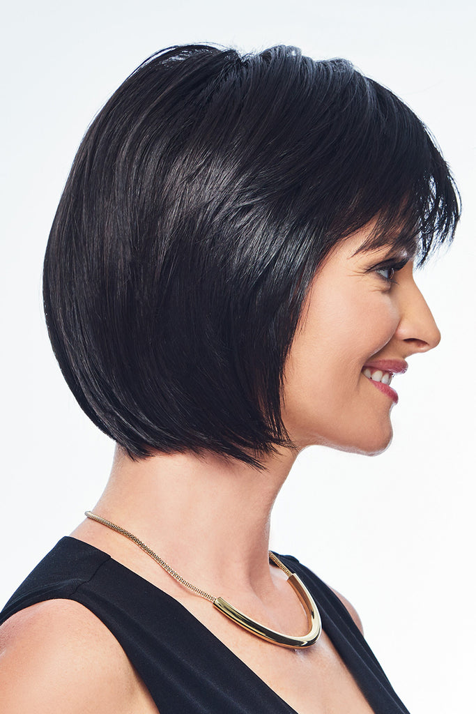 Side view of a woman wearing a short cut bob with bangs. 
