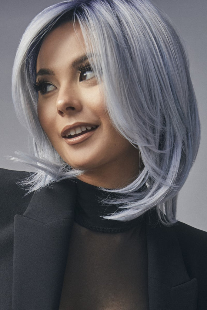 Side view of women modeling a bold and daring wig with high density and heat friendly synthetic fibers.
