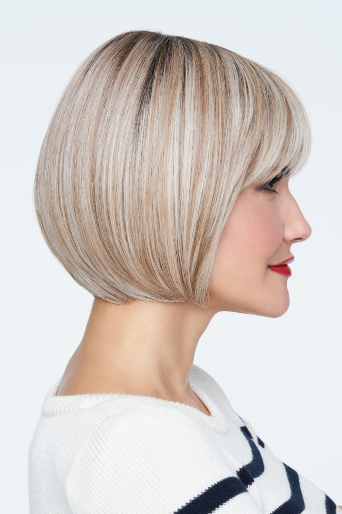 Side view of model showing a cool platinum blonde w/ subtle highlights and med brown roots.