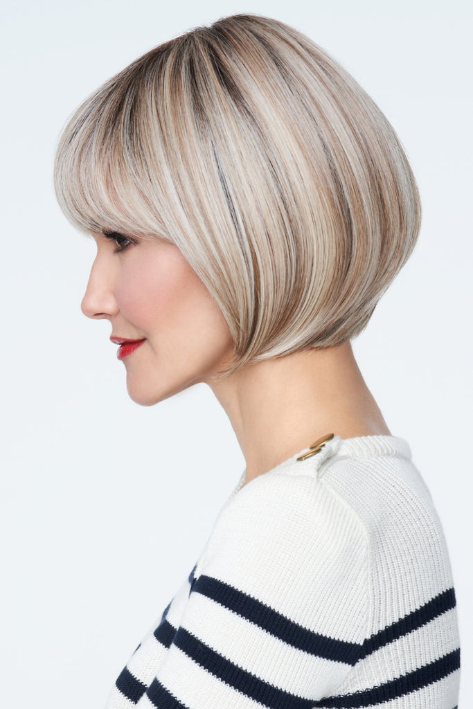 Model styling a chin length bob with a full bang.