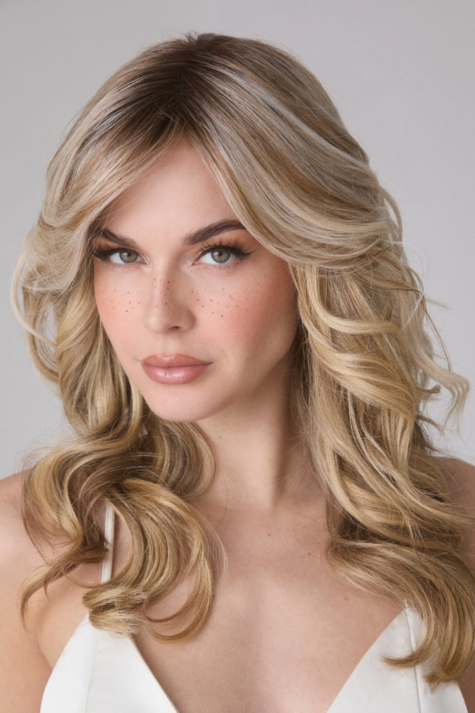 Woman wearing a medium length, wavy top piece.