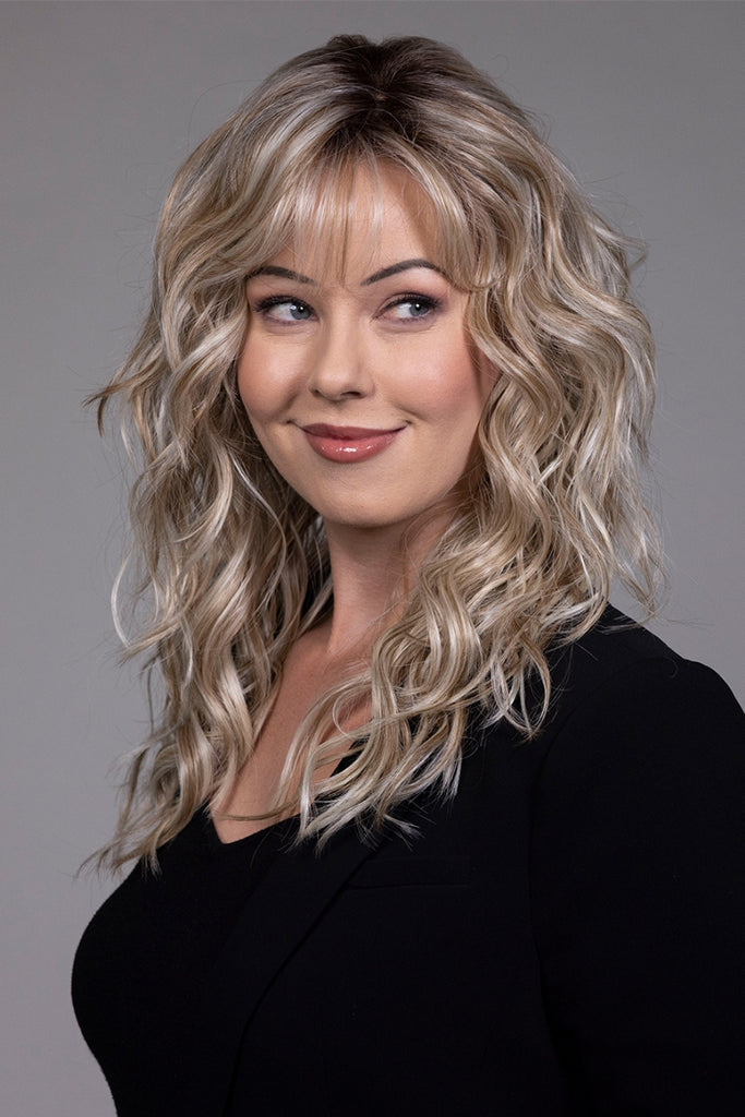 Model styling a curly wig with bangs.