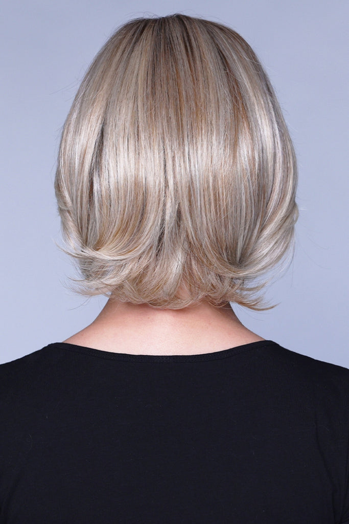 Back view of a cool blonde wig with a touch of honey blonde blended throughout and a dark root.
