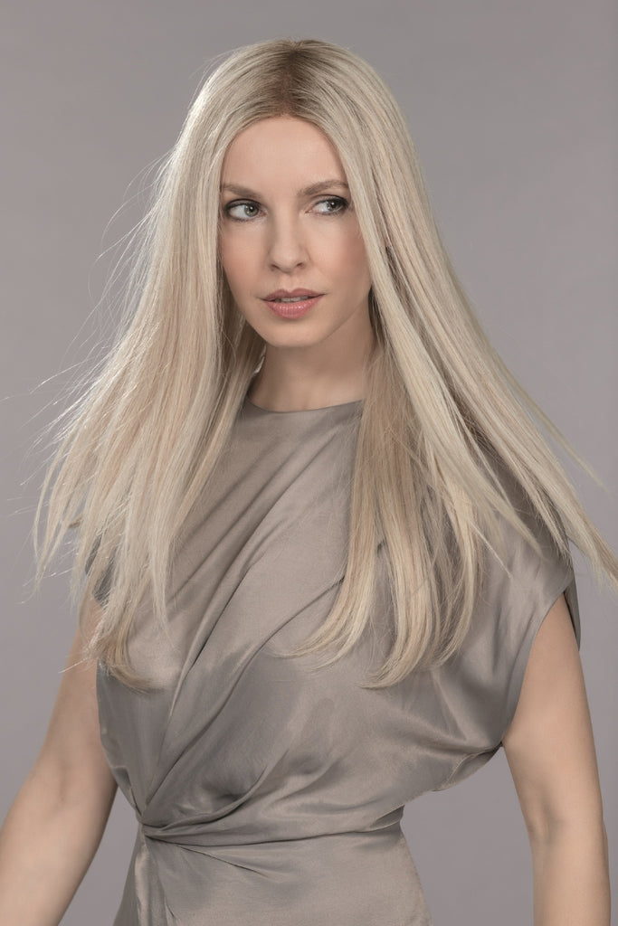 Woman wearing Diamond, a long human hair wig, in the color Light Champagne Rooted.