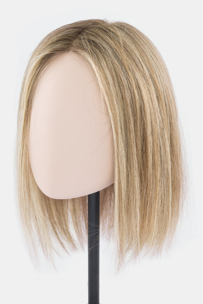 The human hair, heat friendly topper on a mannequin.