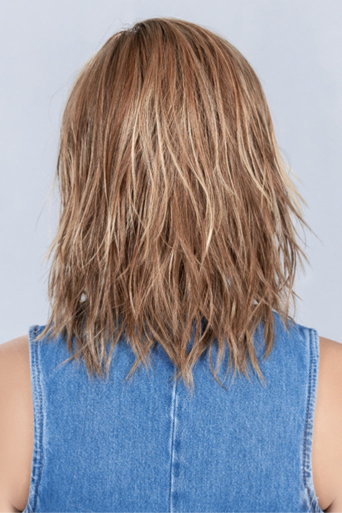 Back of woman wearing a shoulder-length, layered style in a caramel blonde color.