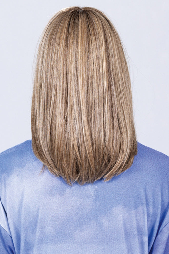 Woman wearing a longer style with bangs in a multi dimensional blonde color.