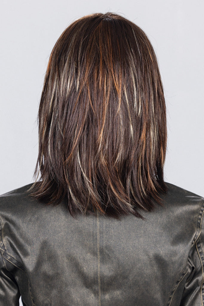 Back of model styling a mid length layered wig.