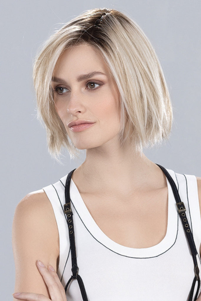 Side of model styling a blonde bob wig.