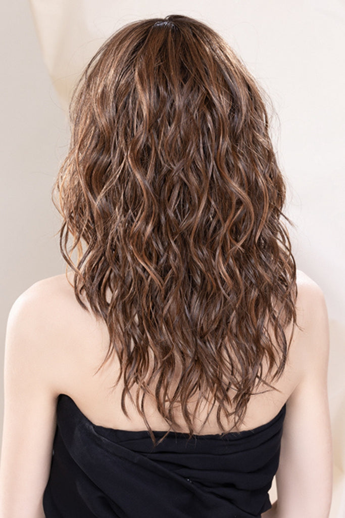 Back of model wearing a long curly wig.