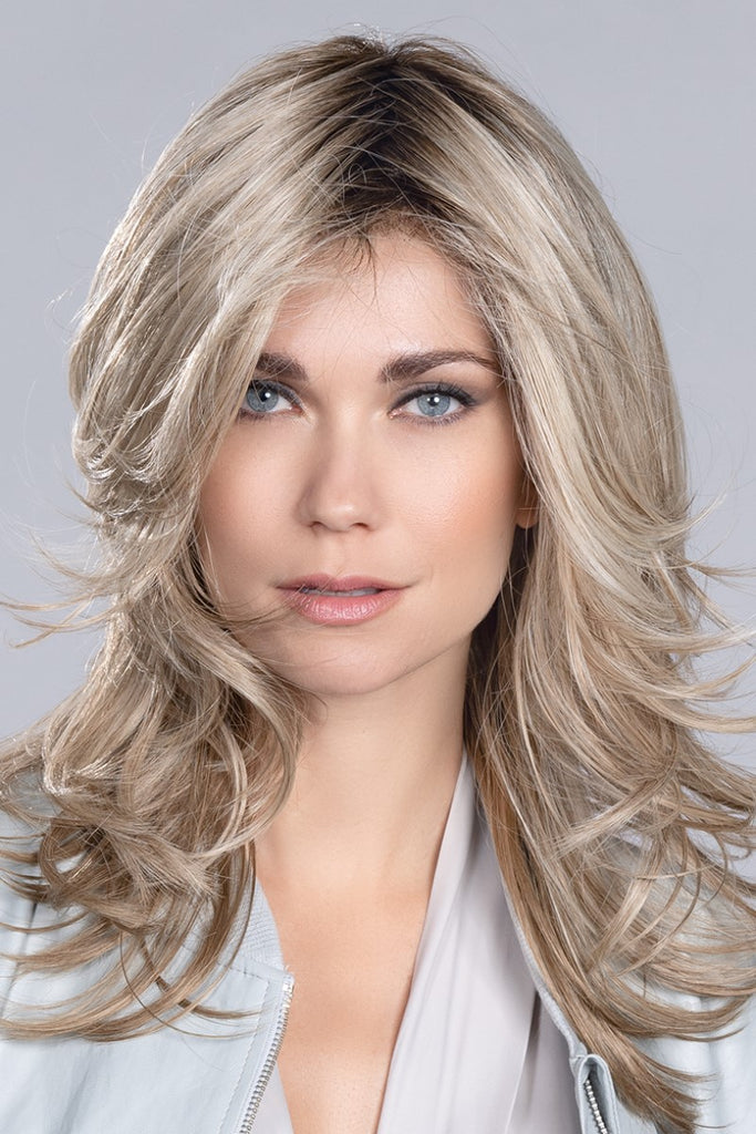 Close up of model wearing a wig in the color Sandy Blonde Rooted.