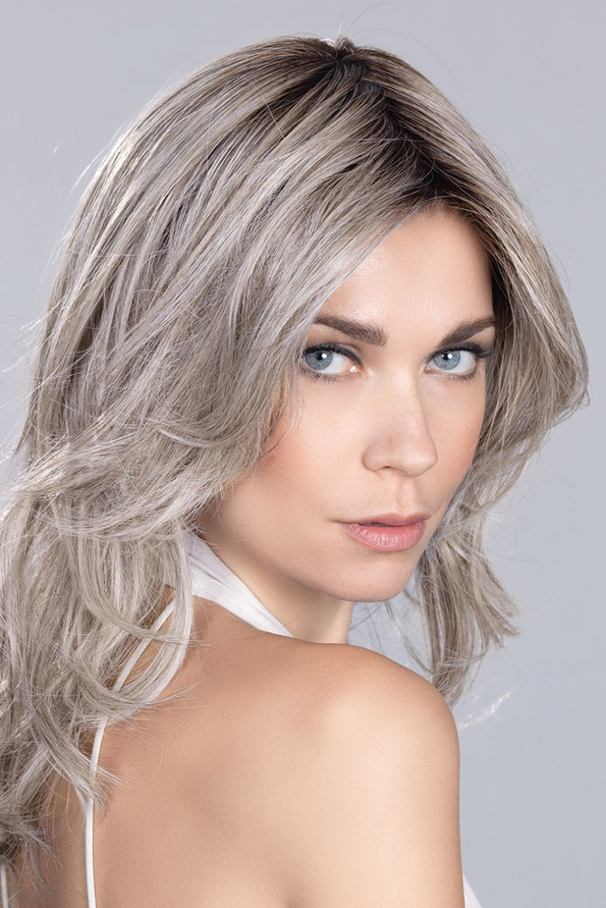 Model wearing a wig in the color Metallic Blonde Rooted.