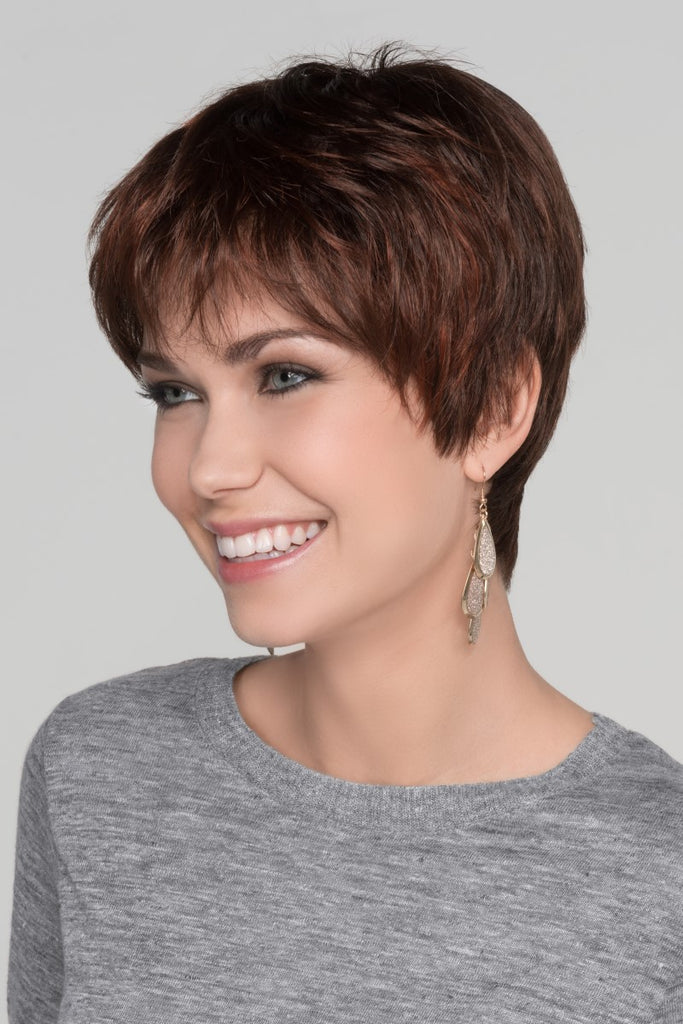 Side view of model styling a short and edgy pixie cut wig.