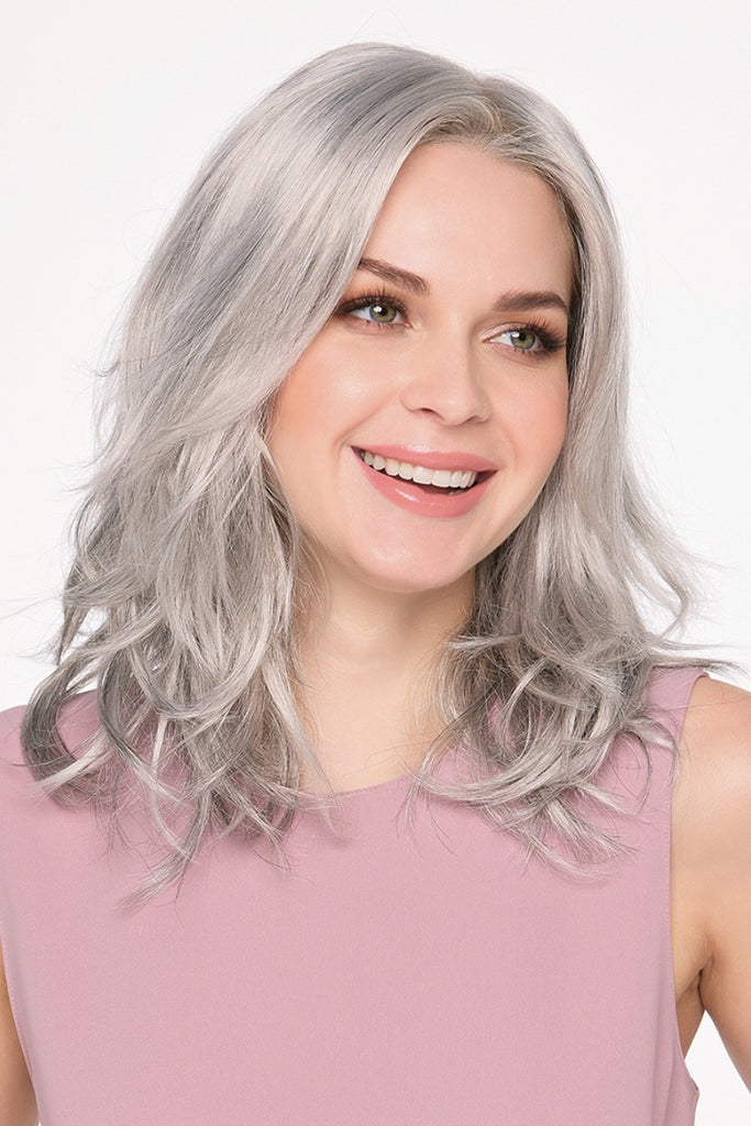 Woman wearing a shoulder-length, wavy wig.