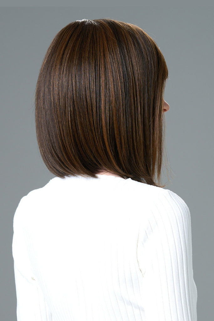 Woman wearing a sleek bob in a dark brunette color.