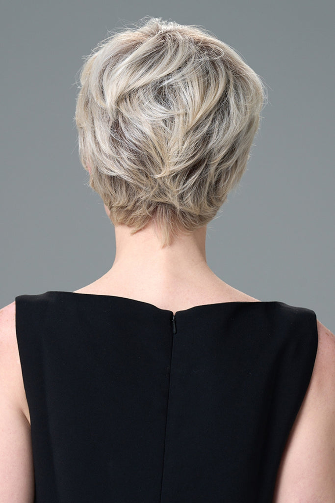 Back of model wearing a short pixie wig.