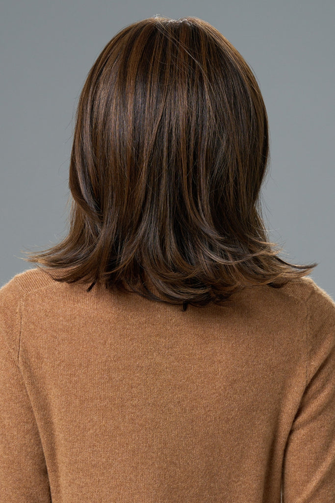Back of model wearing a long layered wig.