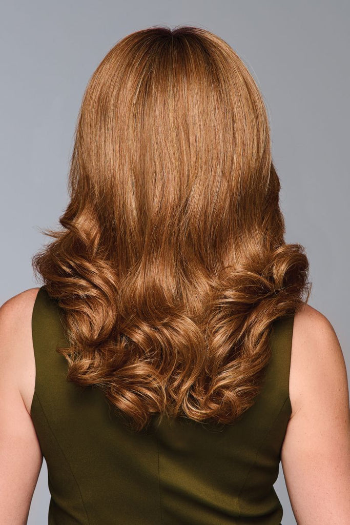 Back of woman wearing a loosely waved wig in the color SS Iced Pumpkin Spice Latte.