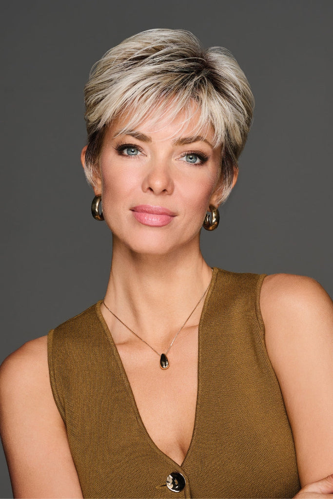 Close up of woman wearing a short length pixie cut wig with bangs.