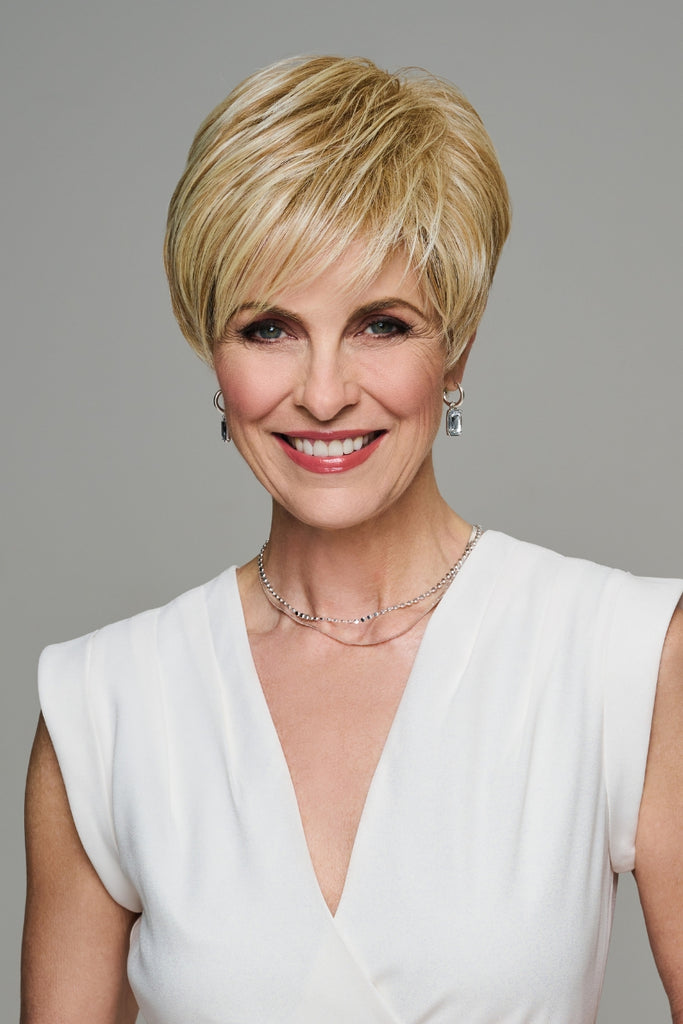 Model wearing a short blonde pixie cut wig.