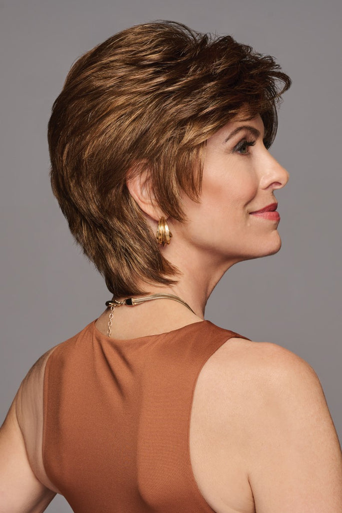 Right side view of woman wearing a wig shown in a warm medium brown color with honey brown and light copper brown highlights.