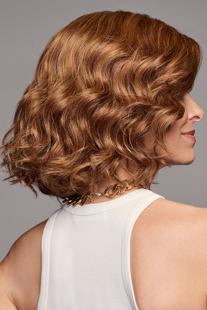 Side of model wearing a curly wig.