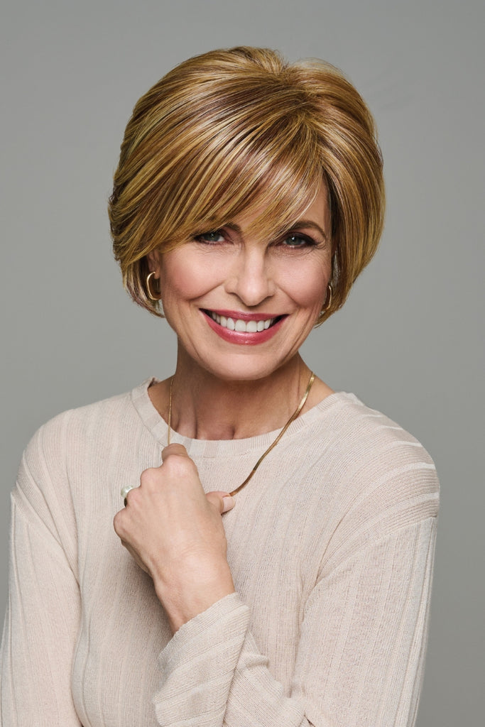 Model wearing a short wig with bangs.