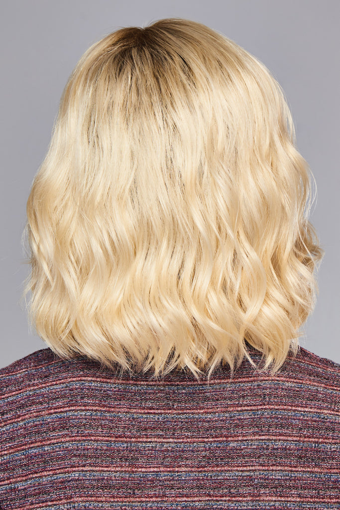 Back of model styling a wavy bob in the color SS Champagne Blonde.
