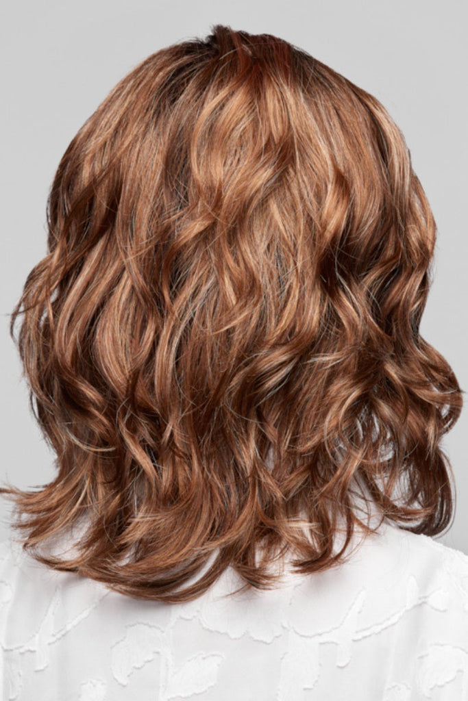 Back of woman wearing a mid-length wavy wig.