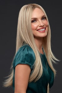Long human hair, blonde wig worn by beautiful woman looking into the camera smiling.