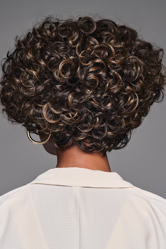 Back of model styling a chic and classy wig with a full crown and tapered sides and nape.