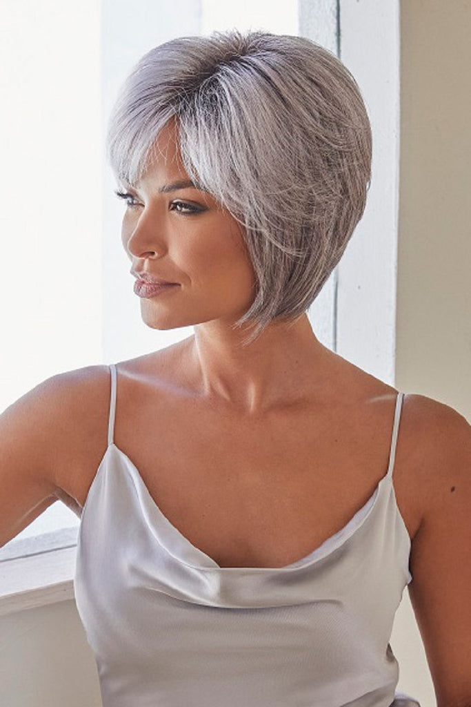 Side photo of a woman wearing a synthetic, straight wig in the color Lilac Silver.