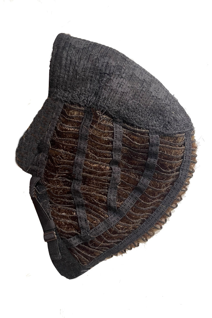 Side view of Joss' cap cosntruction, showing the wedtings and adjustable tab.