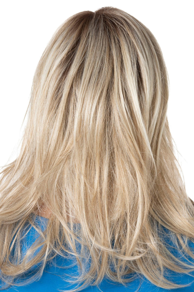 Back of woman wearing a long, layered style in a dimensional blonde color.