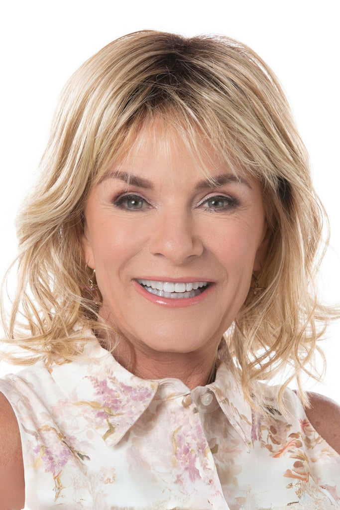 Model wearing a medium length, lightly layered wig with airy bangs.